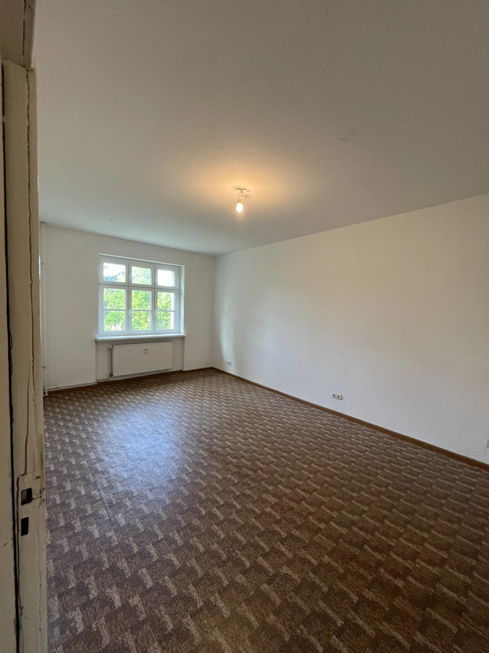 Cleared room with parquet floor and bare walls after the clearout