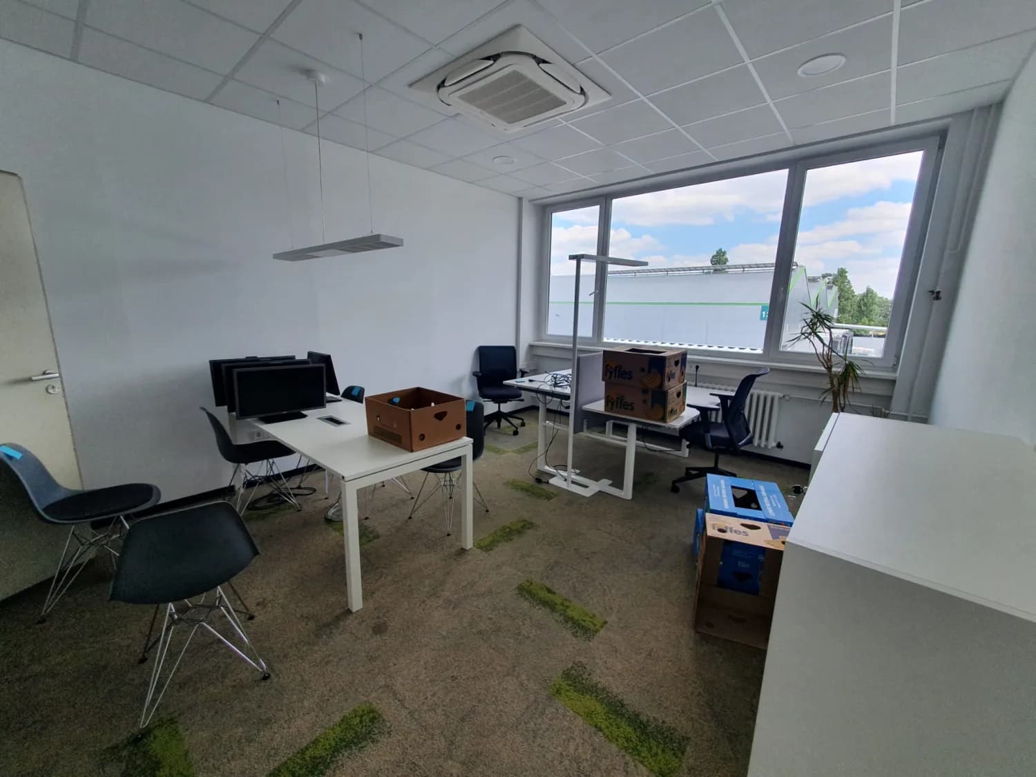 Bright Berlin office with desks, office chairs and moving boxes during a commercial clearance