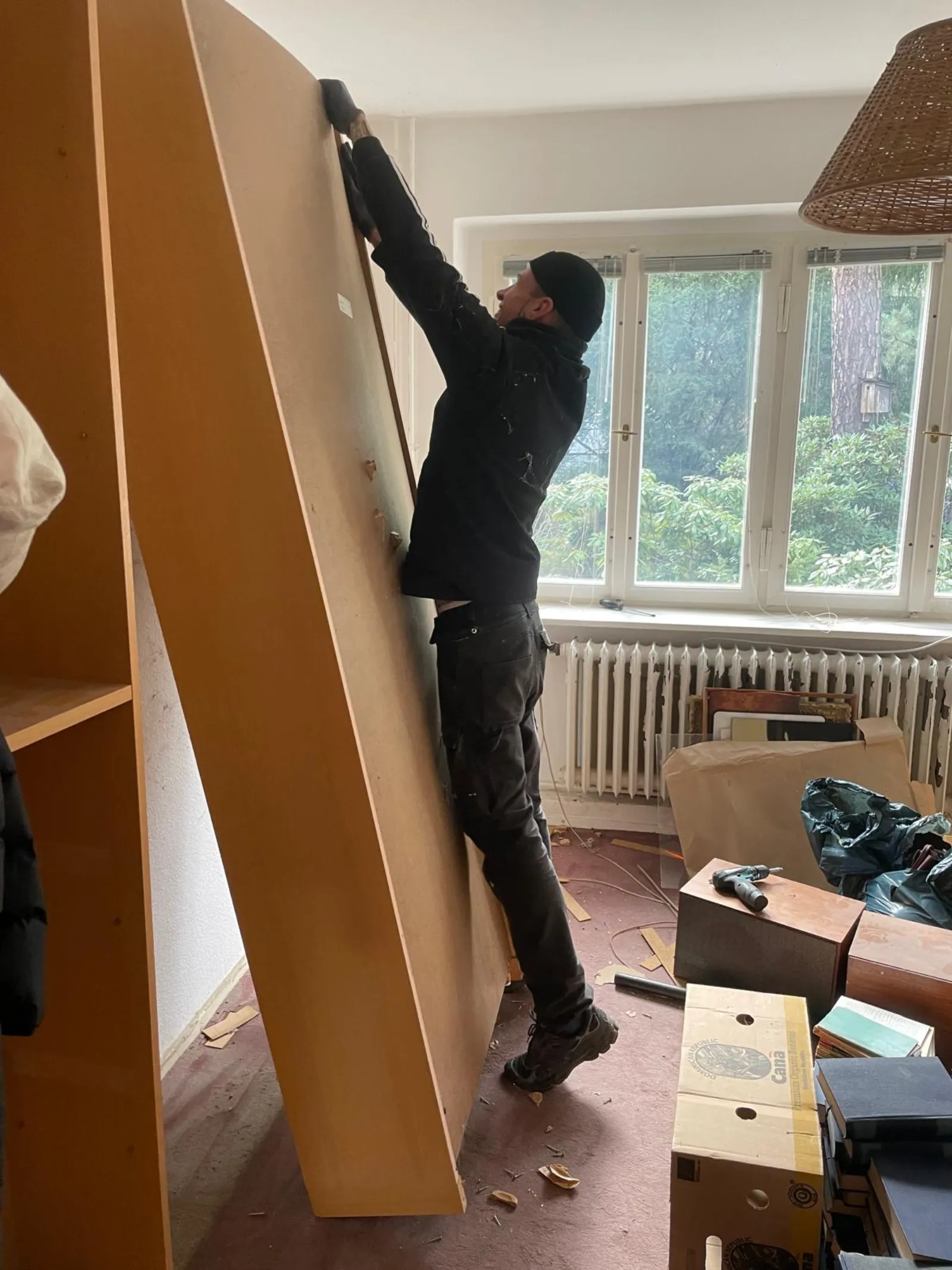 Mitarbeiter von Alles4You trägt eine zerlegte Schrankwand aus dem Zimmer