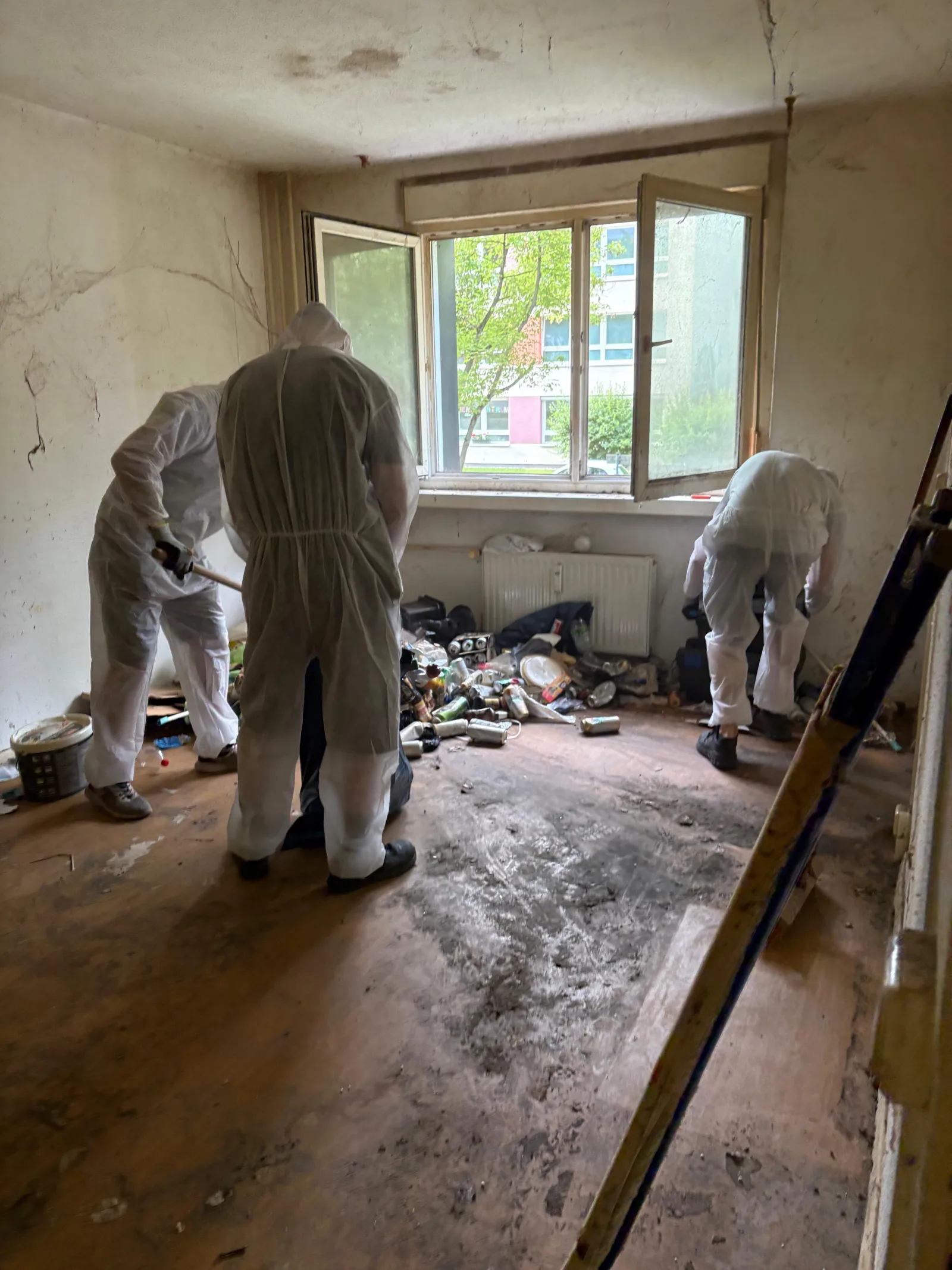 Team im Schutzanzug räumt eine vermüllte Wohnung in Berlin