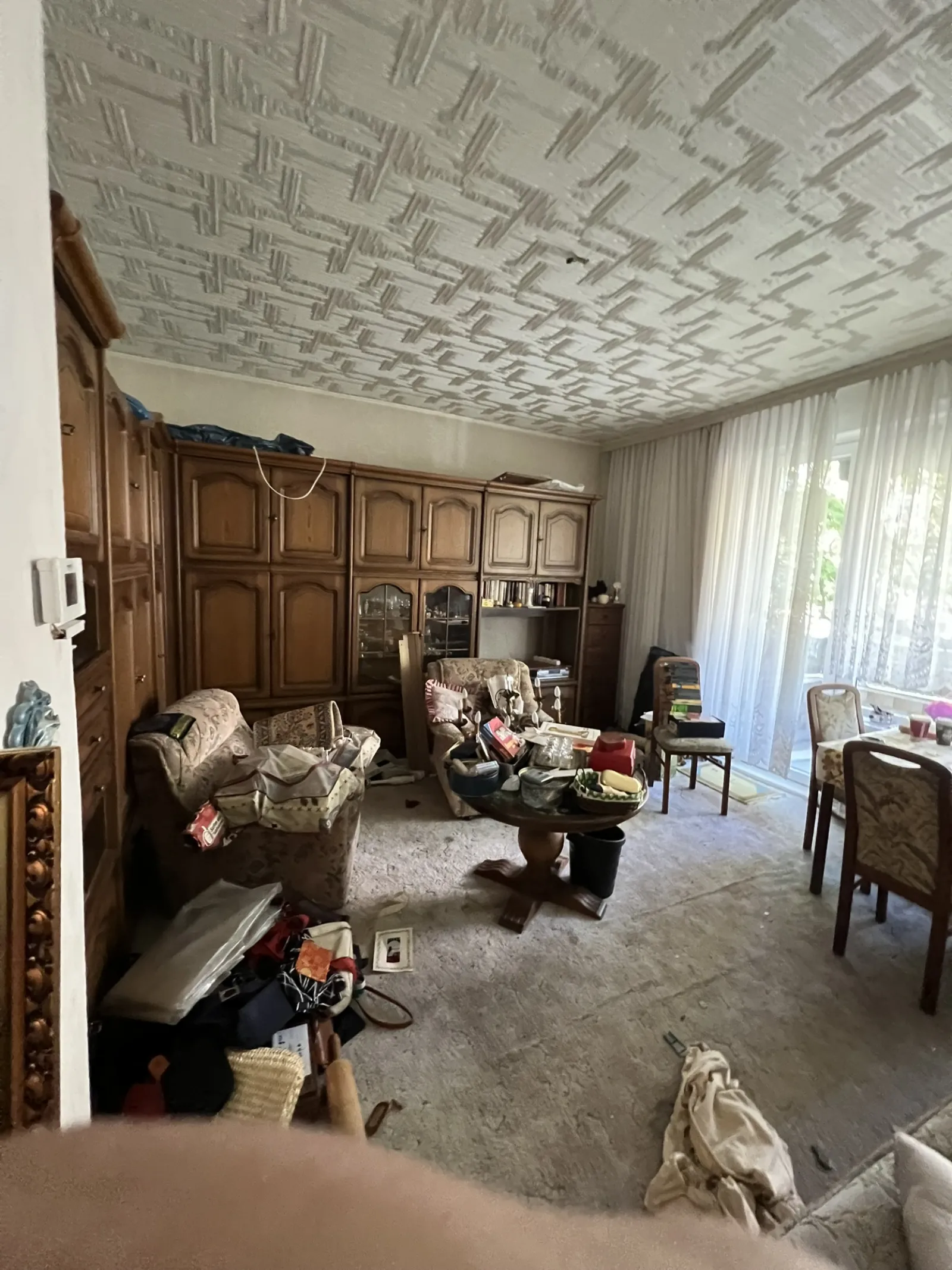 Großes Wohnzimmer mit massiver Schrankwand und Sitzgarnitur vor der Räumung
