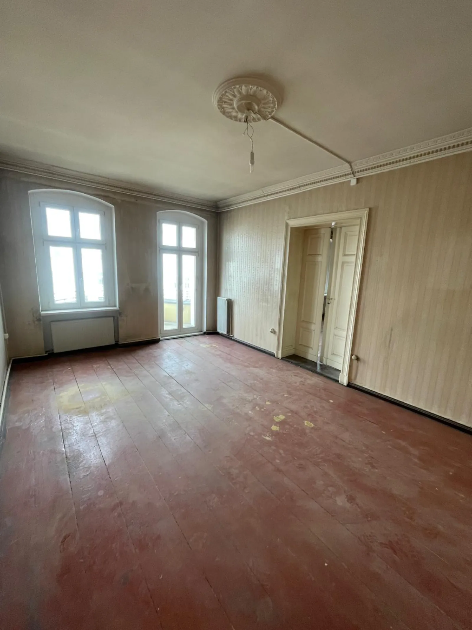 Geräumtes helles Altbau-Zimmer mit zwei Bogenfenstern und Stuckrose