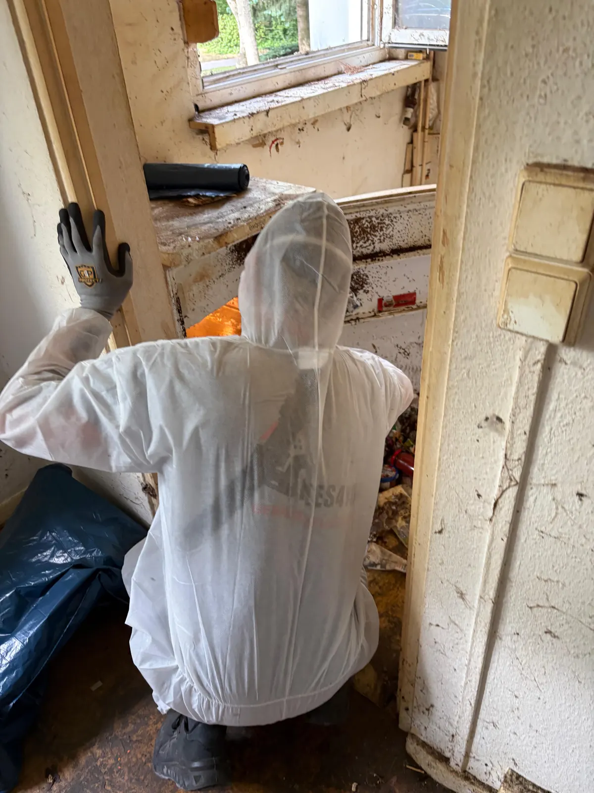 Mitarbeiter von Alles4You arbeitet sorgfältig in einer Messie-Wohnung